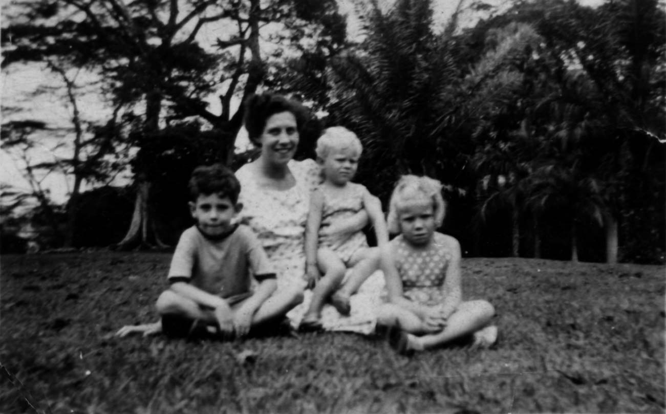 Image: a black-and-white photo of a young mother and three small children